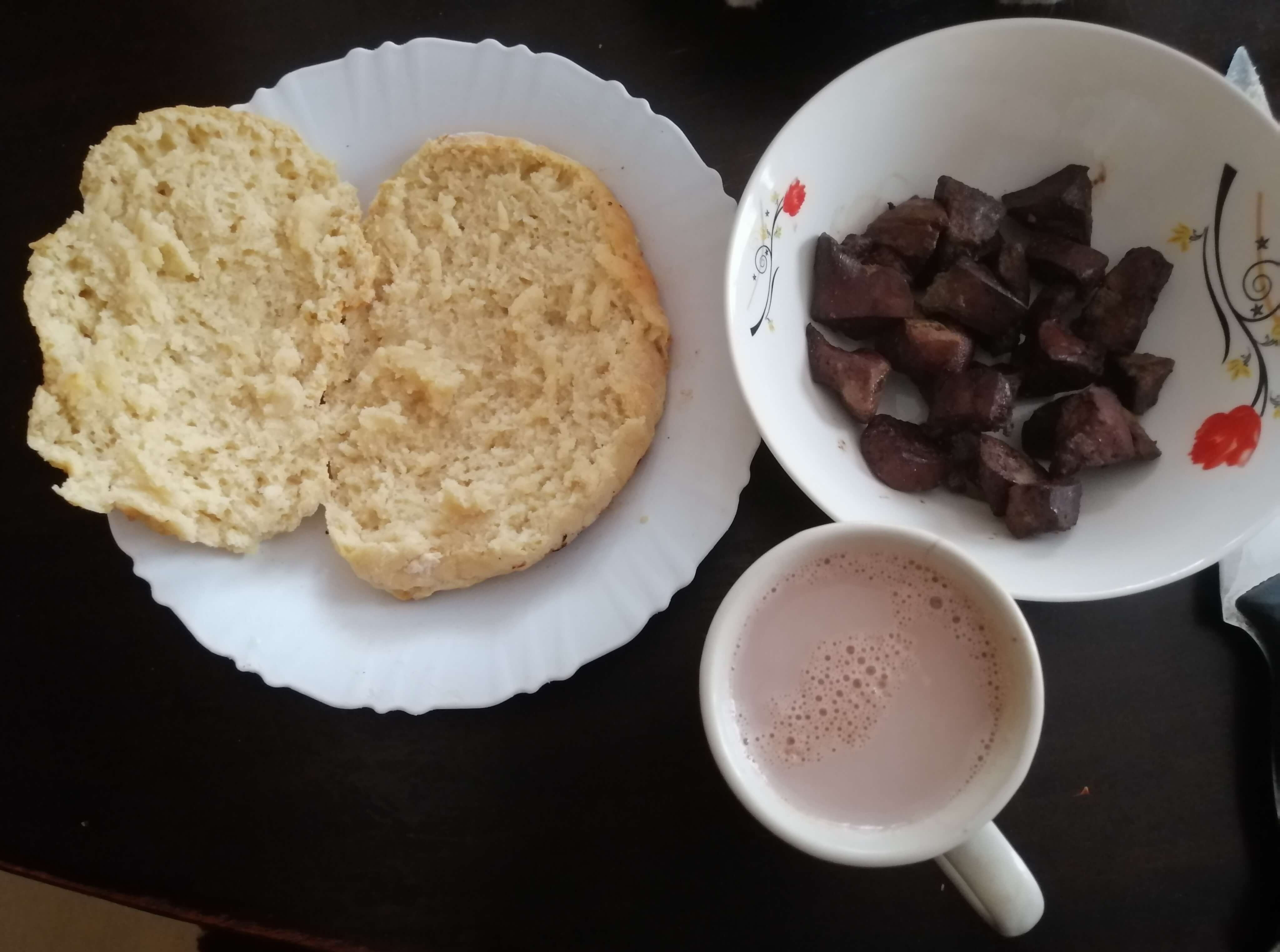 Fresh bread, a bowl of sheep liver and a cup of hot chocolate